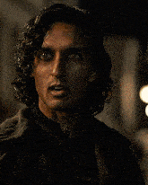 a close up of a man 's face with long hair