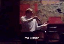 a man singing into a microphone with the name mc kristian on the bottom right