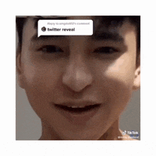 a close up of a man 's face with a reply to omgdoll02 's comment that says twitter reveal