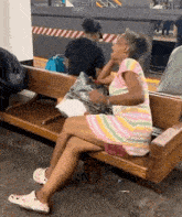 a woman sitting on a bench with her legs crossed