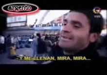 a man is smiling in front of a crowd and says mira mira on the screen