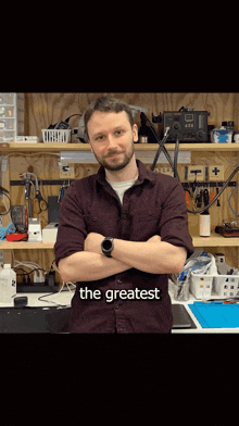 a man with his arms crossed stands in front of a workbench with the words the greatest on the bottom