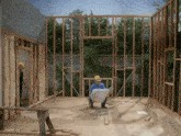 a man wearing a hard hat is kneeling in a room with a drawing on the floor