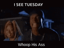 a man and a woman are standing next to each other in a dark room and the man is making a funny face .