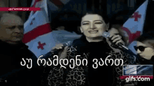a woman singing into a microphone with the words gifs.com in the lower left corner