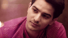 a close up of a man 's face wearing a pink vest