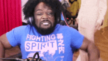 a man wearing headphones and a blue shirt that says fighting spirit .