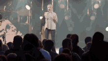 a woman singing into a microphone in front of an audience