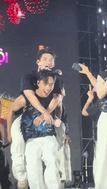 a man is carrying another man on his shoulders on stage