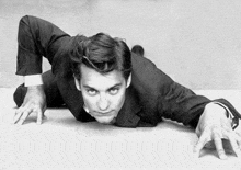 a man in a suit crawling on the floor with his hands outstretched