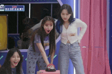 three girls are playing a game and one of them is pressing a button that says 000