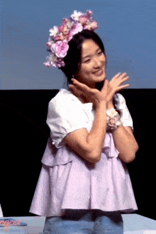 a woman wearing a flower crown stands in front of a sign that says " ginger "