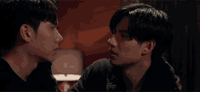 a couple of men are looking at each other in a room .