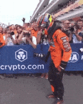 a man stands in front of a sign that says crypto.com on it