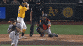 a baseball player is swinging at a pitch while a catcher watches
