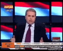 a man in a suit and tie is giving a speech on a television show .