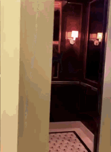 a dark elevator with a light on the side of the door