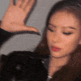 a blurry picture of a woman 's face with her hand in the air