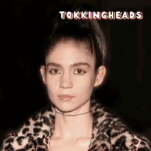 a woman wearing a leopard print jacket with the words tokingheads on the bottom