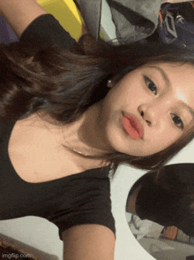 a girl in a black shirt is taking a selfie with imgflip.com at the bottom