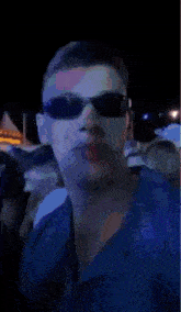 a blurry picture of a man wearing sunglasses in a crowd