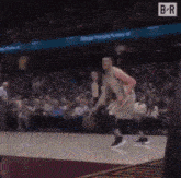 a basketball player is dribbling a basketball on a court .