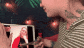 a woman with a tattoo on her neck is holding a pair of scissors in front of a laptop screen