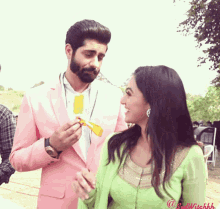 a man in a pink suit is feeding a woman an ice cream