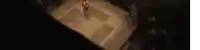 a man is standing in a boxing ring in a dark room with a checkered floor .