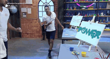 a man is standing in front of an easel with a painting of the word power on it .