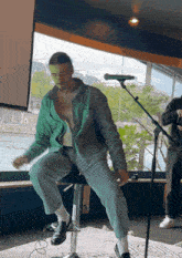 a man sitting on a stool in front of a microphone
