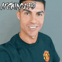 a man wearing a black shirt with a manchester united logo on the front