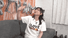 a woman wearing a white t-shirt that says i love imoo