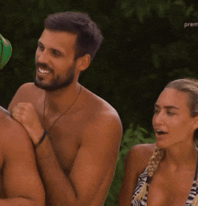 a man and a woman are standing next to each other and the woman is wearing a zebra print bikini top