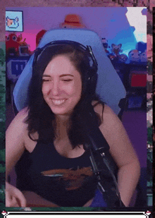 a woman wearing headphones is smiling and sitting in a chair with a microphone