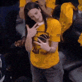a woman wearing a yellow shirt that says ' golden state ' on it