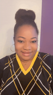 a woman wearing a plaid sweater with a yellow collar