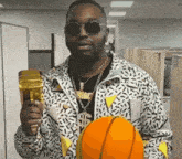 a man wearing sunglasses is holding a basketball and a gold cup