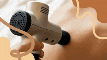 a person is holding a massage gun on their back