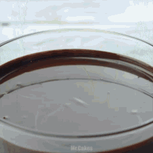 a close up of a glass of chocolate sauce with the words mr.cakes written on the bottom