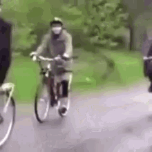 a man wearing a mask is riding a bike on a road .