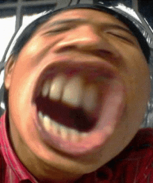 a close up of a man making a funny face with his mouth wide open .