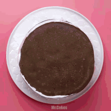 a chocolate cake on a white plate with mr.cakes written on the bottom right