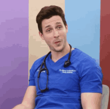 a man with a stethoscope around his neck is wearing a blue scrub top that says dr. michael henderski on it