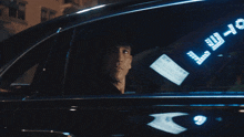 a man is looking out of a car window with a sign that says trust