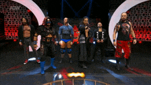 a group of wrestlers standing in front of a sign that says aew on it