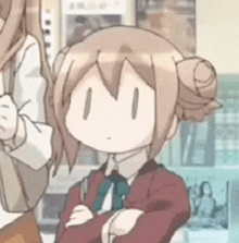a girl with a bun on her head is standing with her arms crossed in a room .