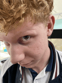 a close up of a person 's face with a blue and white jacket on