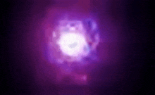 a purple light is shining in the dark with a blurred background .