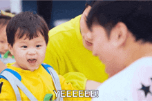a baby is being held by a man and the words yeeeee are next to it